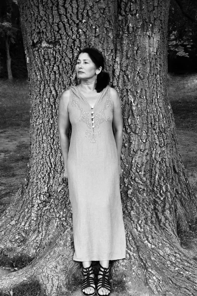 Kvinna nära ett träd i parken — Stockfoto