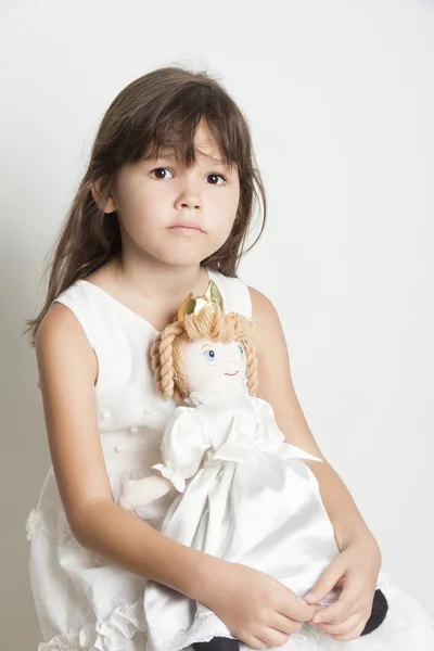 Menina bonita brincando com sua boneca — Fotografia de Stock