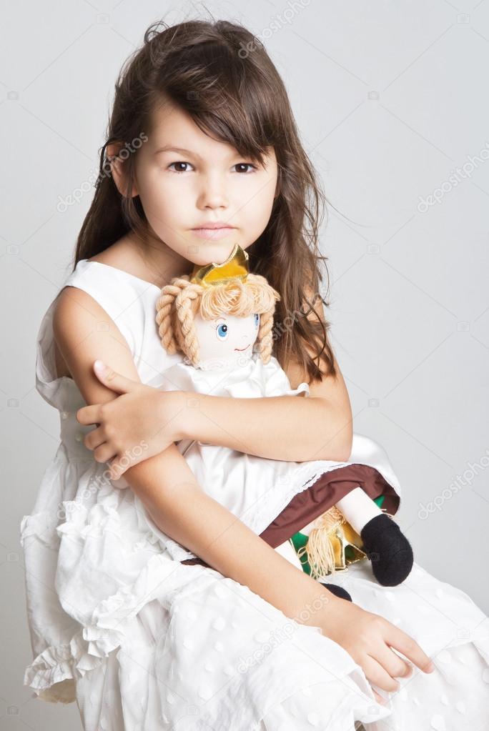 Beautiful girl playing with her doll