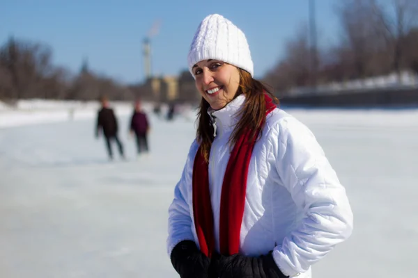 Retrato de uma jovem mulher em uma pista de patinação durante o inverno — Fotografia de Stock