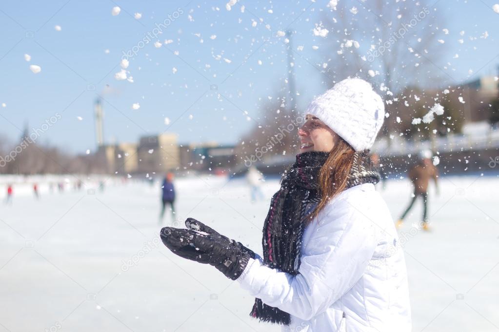 Happy girl playing in the snow during winter