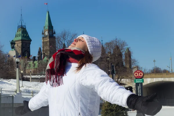 Young woman basks in the warm winter sun in front of Canada's Pa — Stock Photo, Image