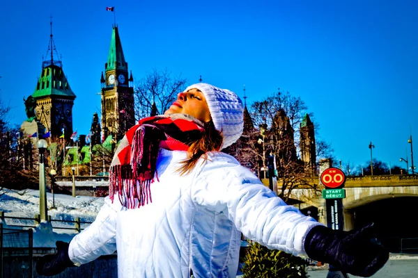 Young woman basks in the warm winter sun in front of Canada's Pa — Stock Photo, Image