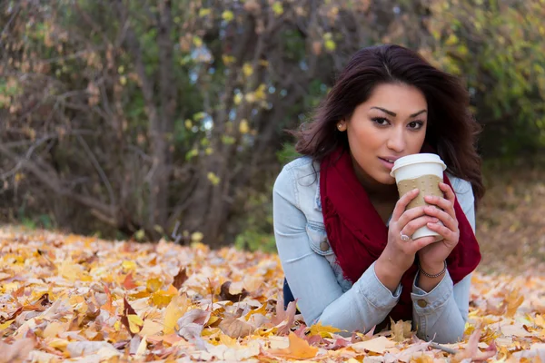 Mulher hispânica desfrutando de um café ao ar livre durante o outono — Fotografia de Stock