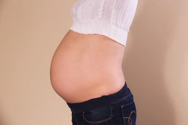 Vista lateral da barriga exposta de uma mulher grávida — Fotografia de Stock