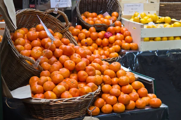 Fresh oranges in baskets at a fruit market