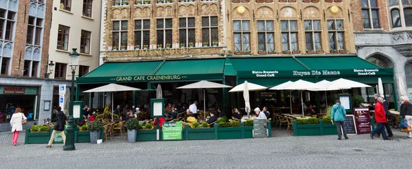 BRUGES / BÉLGICA - 14 de abril de 2014: Los turistas en los restaurantes en el —  Fotos de Stock