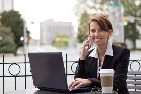 Sorridente donna d'affari che lavora al telefono al caffè all'aperto sh — Foto Stock