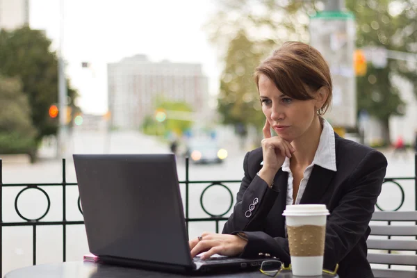 Business woman working on laptop at outdoor coffee shop — Stock Photo, Image