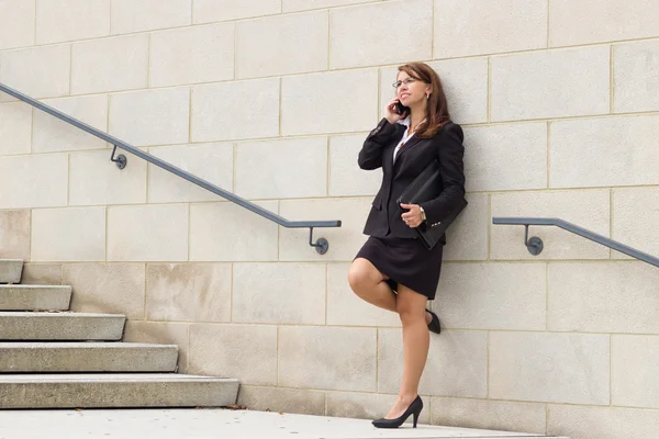 Mujer de negocios con teléfono celular en entorno urbano —  Fotos de Stock