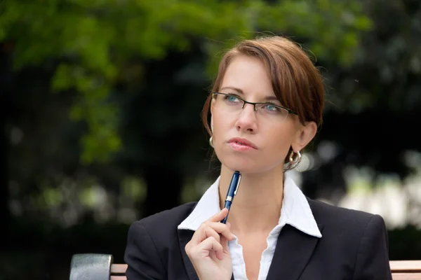 Portret van aantrekkelijke zakenvrouw met glazen denken — Stockfoto