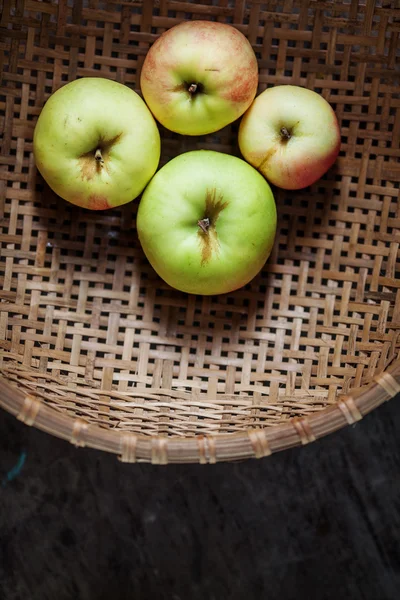 Cuatro manzanas en una canasta — Foto de Stock