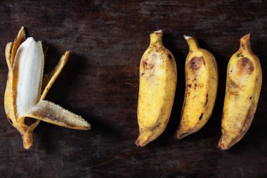 kahverengi ahşap bir masa üzerinde olgunlaşmış muz