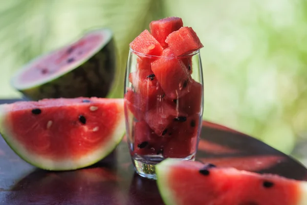 Watermelon pieces and slices in a glass on a dark table in Vietnam — Stock Photo, Image