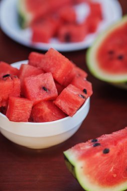 karpuz parçalar ve koyu ahşap tabl üzerinde iki tabak dilimleri