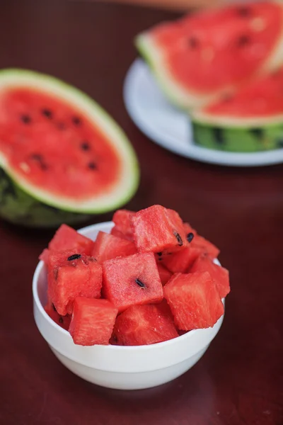 Wassermelonenstücke und Scheiben in zwei Tellern auf einem dunklen Holztisch — Stockfoto