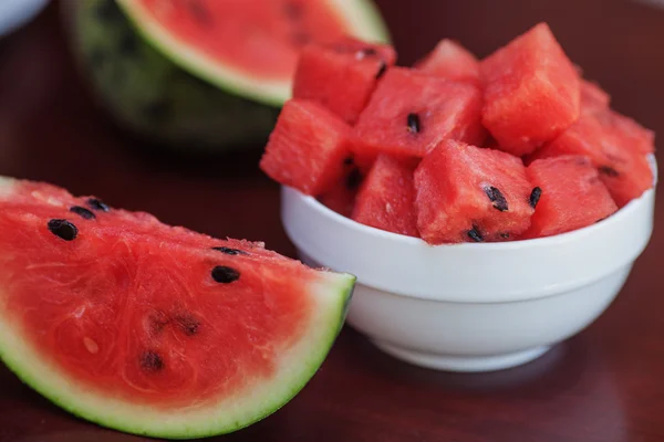 Wassermelonenstücke und Scheiben in zwei Tellern auf einem dunklen Holztisch — Stockfoto