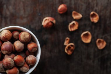 karanlık bir tablo üzerinde beyaz bir fincan fındık