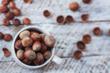 Beyaz bir tablo üzerinde beyaz bir fincan fındık