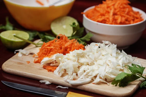 Chopped cabbage, Grated  carrot and leaves of celery on a carvin — Stock Photo, Image