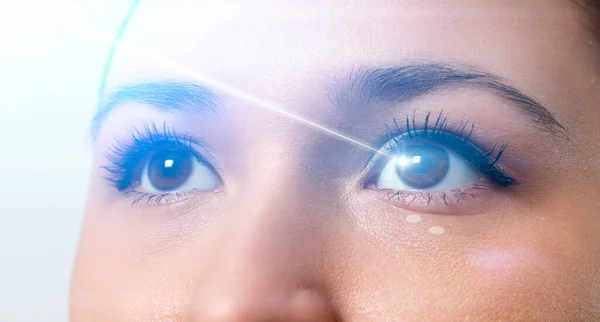 Lazer ışınlı bir kadının gözü. Lazer görüş düzeltmesi kavramı.