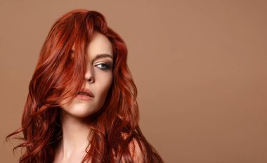 Bej arka planda kızıl saçlı güzel bir kadının güzel portresi. Kopyalama alanı ile.