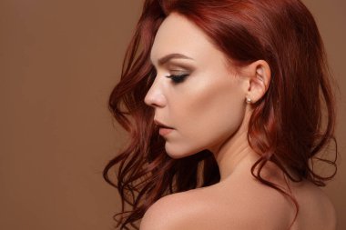 Bej arka planda kızıl saçlı güzel bir kadının güzel portresi. Kopyalama alanı ile.