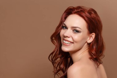 Bej arka planda kızıl saçlı güzel bir kadının güzel portresi. Kopyalama alanı ile.