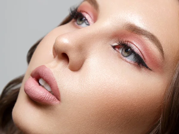 Gri bir arka planda izole edilmiş güzel bir genç kadının portresi.