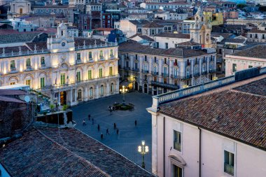 Palazzo dell Universita 'nın saat kulesinin ve Catania, İtalya' daki Piazza dell Universita 'nın alacakaranlık manzarası.
