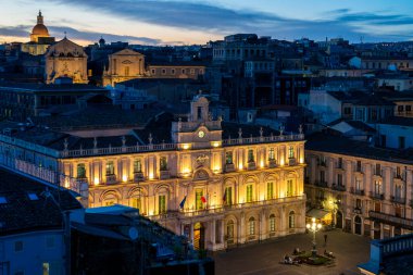 Palazzo dellUniversita 'nın saat kulesinin ve Catania, İtalya' daki Piazza dellUniversita 'nın alacakaranlık manzarası.