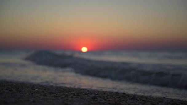 Foto tranquilla di un tramonto sul mare. Il sole rosso tramonta nel mare. Onde in arrivo. Il cielo è colorato di rosso — Video Stock
