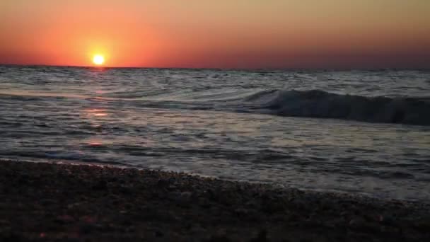 Ηρεμία εικόνα του ηλιοβασιλέματος της θάλασσας. Ο κόκκινος ήλιος δύει στη θάλασσα. Εισερχόμενα κύματα. Ο ουρανός είναι χρωματιστός κόκκινος — Αρχείο Βίντεο