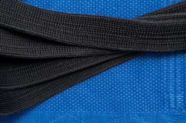 Yukarıdan manzara. Judo dersleri için kimono ve siyah kuşak. Kimono mavi. Arkaplan, doku