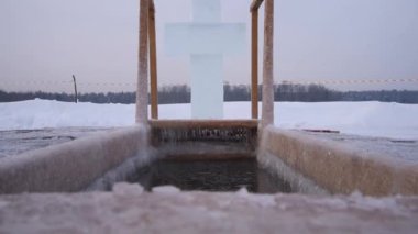 Epifani ziyafetinde yıkanmak için bir delik. Açık havuz, göl. Buzdan bir haç.