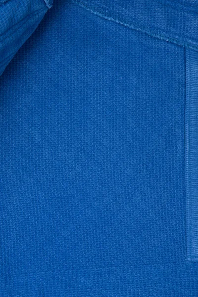 柔道课的棉制和服的质地。蓝色面料特写。从顶部看问题. — 图库照片