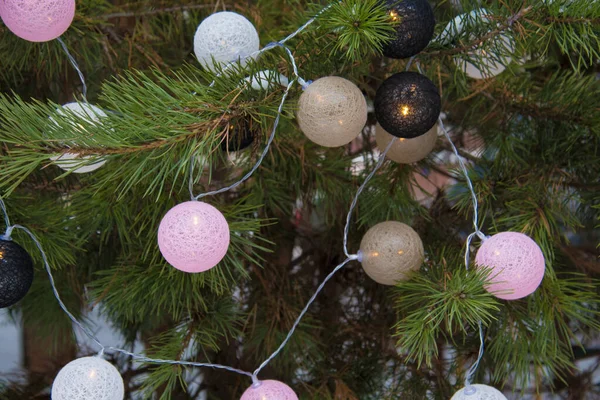 Новогодний фон. На заснеженных еловых лапах расположены шары-гирлянды. — стоковое фото