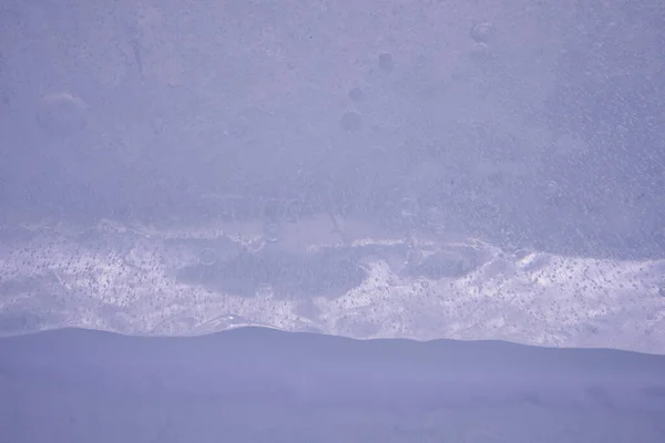 特写冰层结构。背景为深蓝色。冬季、霜冻和寒冷. — 图库照片