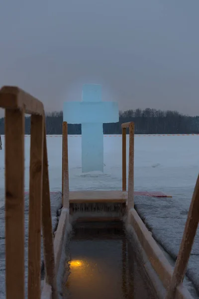 A hole for bathing on the feast of Epiphany. Outdoor plunge pool, the lake. A cross made of ice
