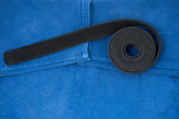 The view from the top. Kimono for judo classes and a black belt. The kimono is blue. Background, texture. — Stock Photo, Image