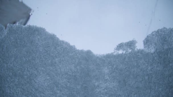 Le processus de fonte de la neige sur un pare-brise de voiture. La neige et la glace fondues glissent progressivement vers le bas. Vue intérieure. Verre chauffé — Video