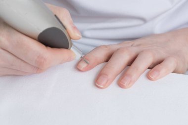 Ev manikürü. Özel bir aletle tırnak bakımı ve tedavisi. Tırnaklar için kişisel bakım, salgın sırasında karantina.