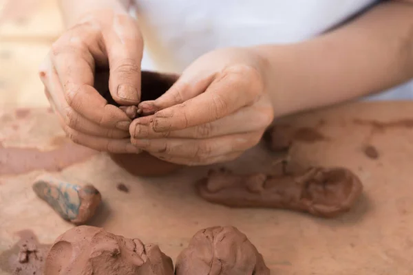 Gros plan des mains d'enfants travaillant avec de l'argile. L'enfant fait des plats et d'autres métiers. La poterie. Concept de Loisirs et Loisirs, développement complet de l'enfant. — Photo