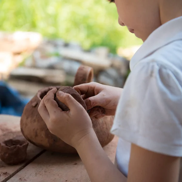 The child makes dishes and various figures from clay. Pottery skills. Hobbies and interests. Childrens education, expanding horizons. — Stock Photo, Image