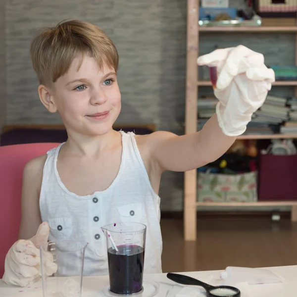 Ein Kinderchemiker bewundert die Ergebnisse eines wissenschaftlichen Experiments. Ein Kinderbiologe untersucht kleine Mikroorganismen. Das Mädchen blickt in ein Reagenzglas. Kluges Kind — Stockfoto