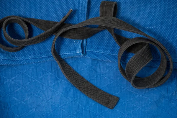 Het uitzicht vanaf de top. Kimono voor judo lessen en een zwarte riem. De kimono is blauw. Achtergrond, textuur. — Stockfoto