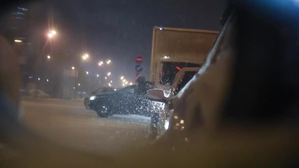 後ろのミラーは渋滞の中に立っている車を示しています 降雪による渋滞 冬の悪天候の概念 雪は大きなフレークの中に落ち — ストック動画
