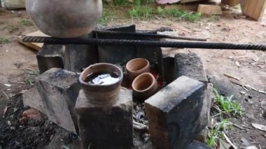 Dumanı tüten bir çaydanlık ve çay fincanı. Kil tencerede ateşte çay hazırlamak. Kamp gezisi, yolculuk..