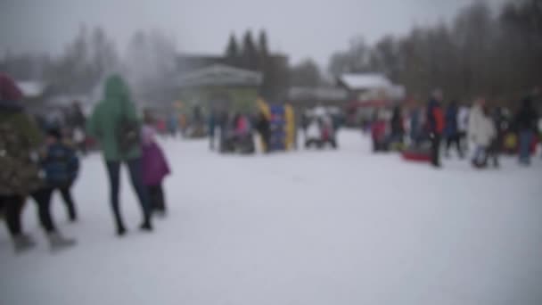 Ein verschwommenes Bild der Winterfestlichkeiten. Es schneit, die Leute haben Spaß. Volksfeste. Verschneiter Winter — Stockvideo