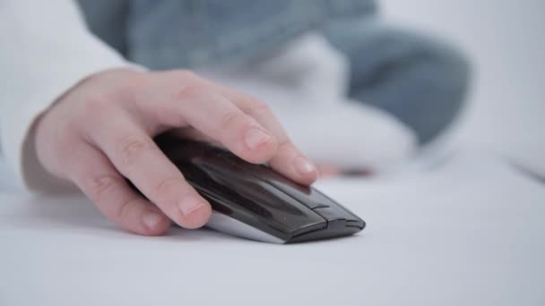 De hand van de kinderen. Het kind is bezig of speelt in de laptop met behulp van een draadloze muis — Stockvideo